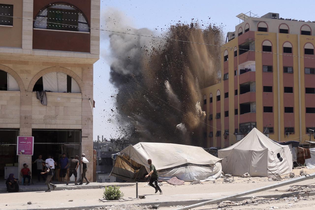 Palestinians rush for cover as smoke billows after an Israeli strike on a building in Jabalia in the northern Gaza Strip on August 20, 2025. (AFP Photo)
