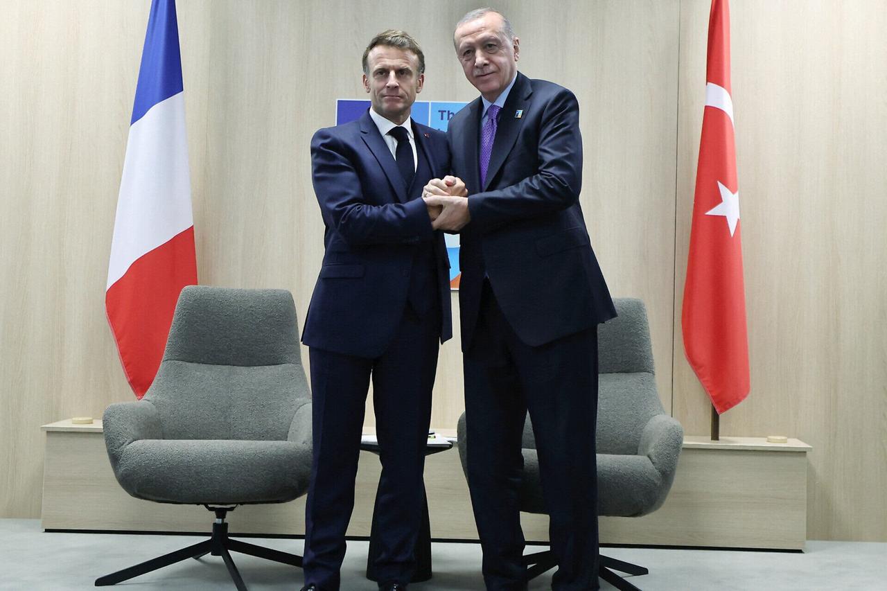 Frances President Emmanuel Macron (L) shaking hands with Turkeys President Recep Tayyip Erdogan during their meeting on the sideline of the North Atlantic Treaty Organization (NATO) summit in The Hague, the Netherlands, June 25, 2025. (Photo by TURKISH PRESIDENTIAL PRESS SERVICE)