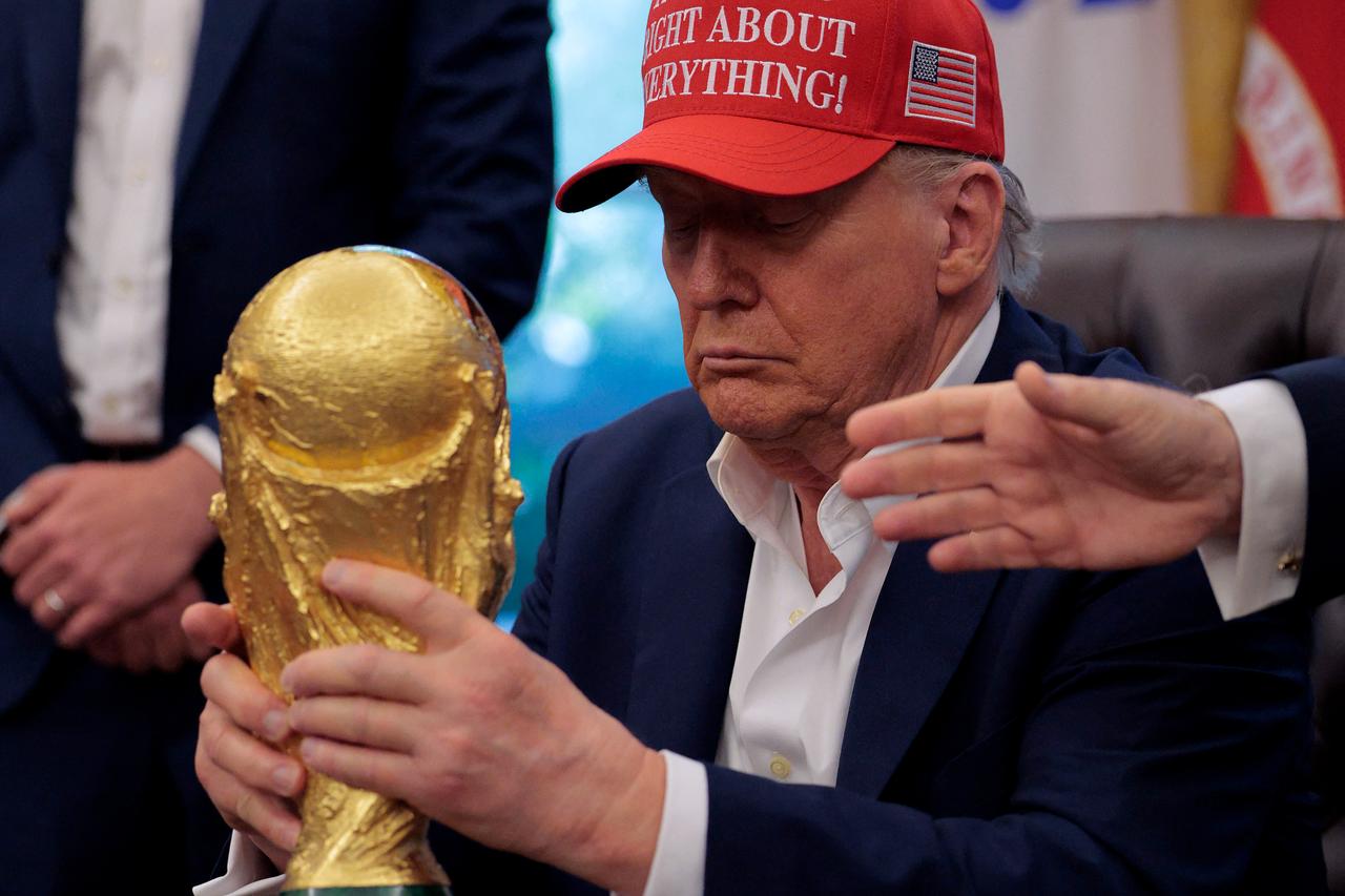 U.S. President Donald Trump holds the World Cup Trophy in the Oval Office, in Washington, D.C, August 22, 2025. (AFP Photo)