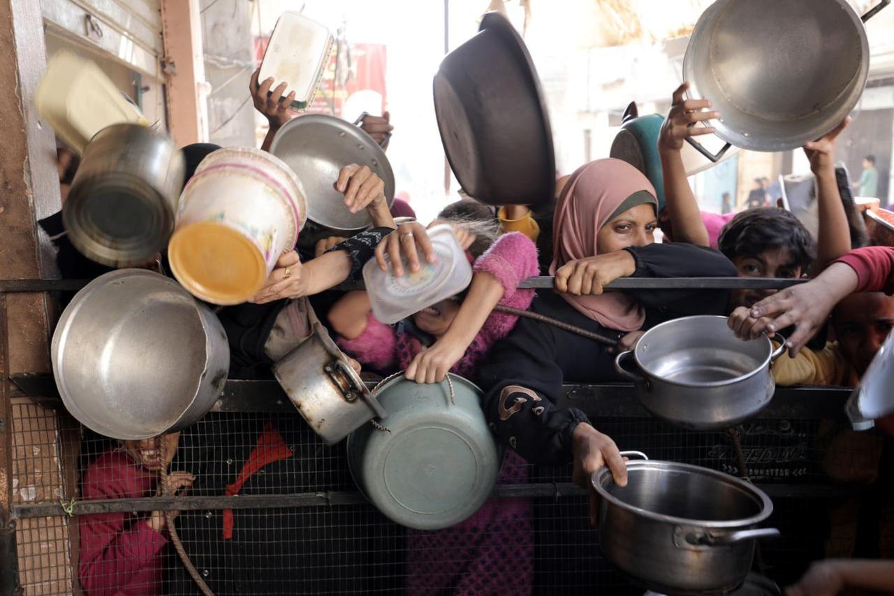 Palestinians, including children, in the Nuseirat refugee camp wait with empty pots for food distributed by an aid organization, as widespread starvation and shortages of basic supplies continue in Gaza City, Gaza, Nov. 08, 2024. (AA Photo)