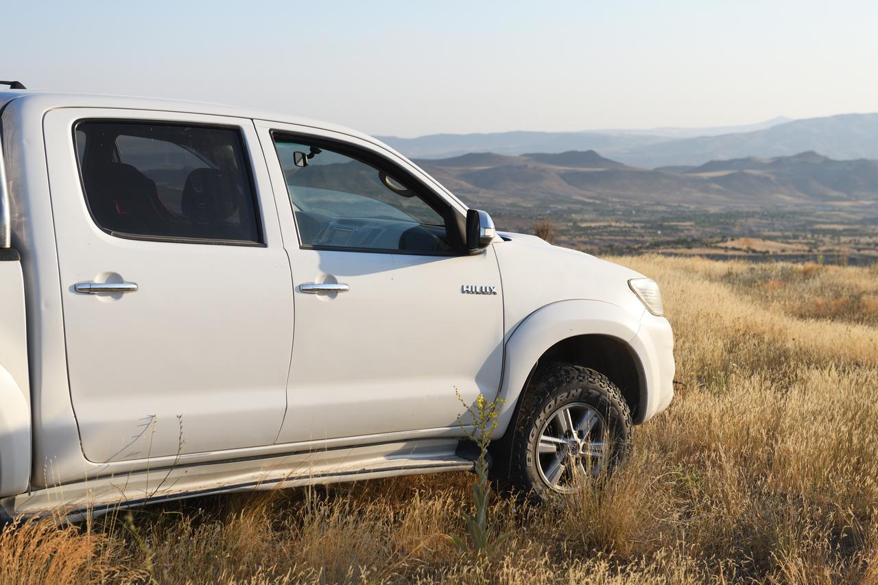 A white Toyota Hilux in a field in Cappadocia, Nevsehir, Türkiye, December 7, 2021. (Adobe Stock Photo)