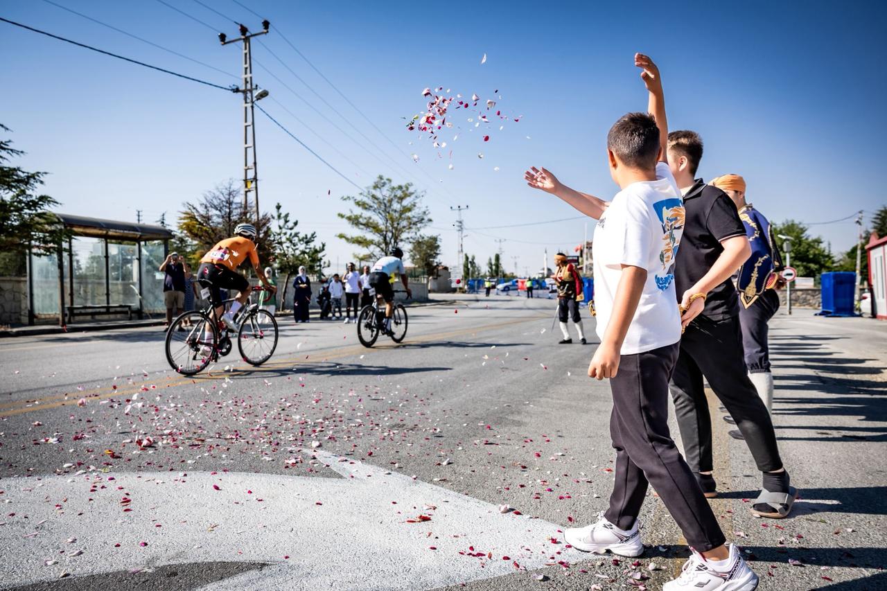 Residents greet cyclists with flowers in Tulumtas Village during the 2025 Gran Fondo Baskent cycling race held in Ankara, Türkiye, Aug. 24, 2025. (Photo via Gran Fondo Baskent team)