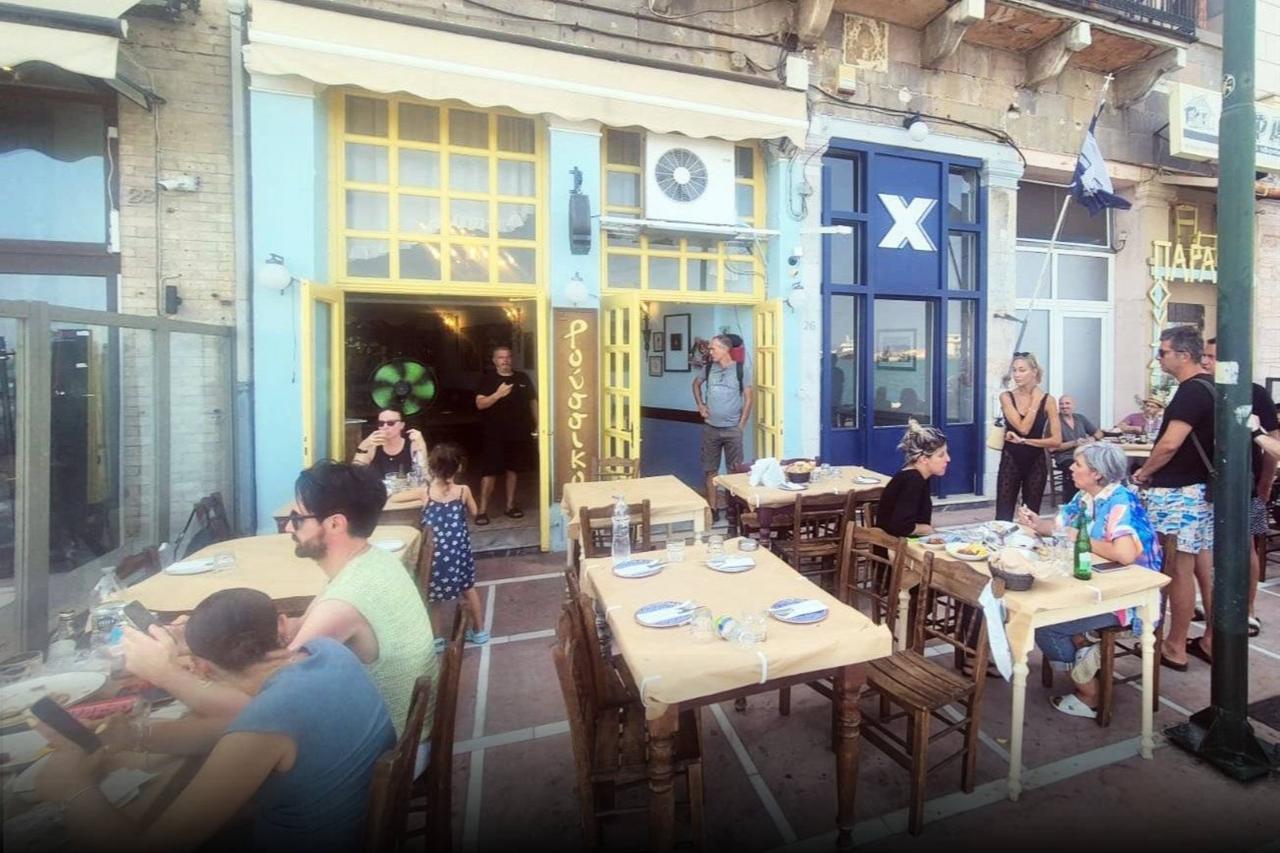 As Acun Ilicali (right, behind the green pole) and his family entered the restaurant Roussiko on the Greek island of Chios, the owner (left) is seen making a hand gesture toward women taking photos, Aug. 22, 2025. (Photo via T24)
