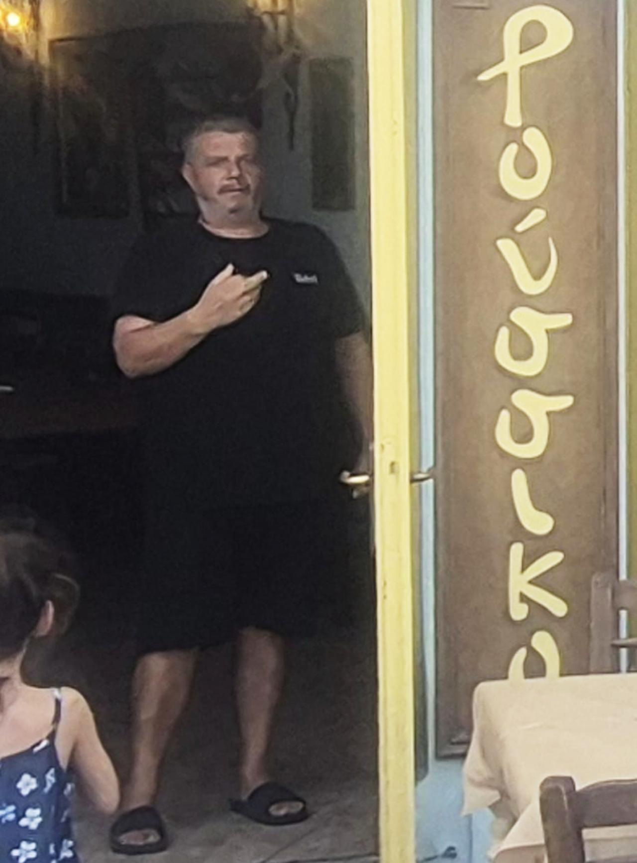 The owner of the restaurant Roussiko on the Greek island of Chios is seen making a hand gesture, Aug. 22, 2025. (Photo via T24)