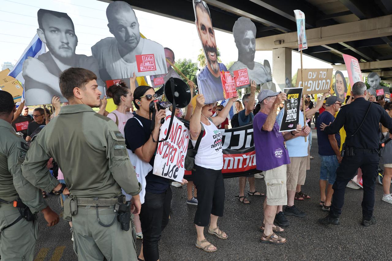 Protesters wave placards as they block a road during a demonstration organised by the families of the Israeli hostages in Tel Aviv on August 26, 2025. (AFP Photo)