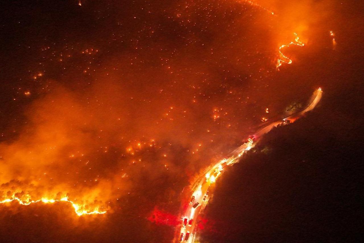Firefighting teams conduct air and ground operations as smoke billows from a forested area in Bursa, Türkiye, July 28, 2025. (AA Photo)
