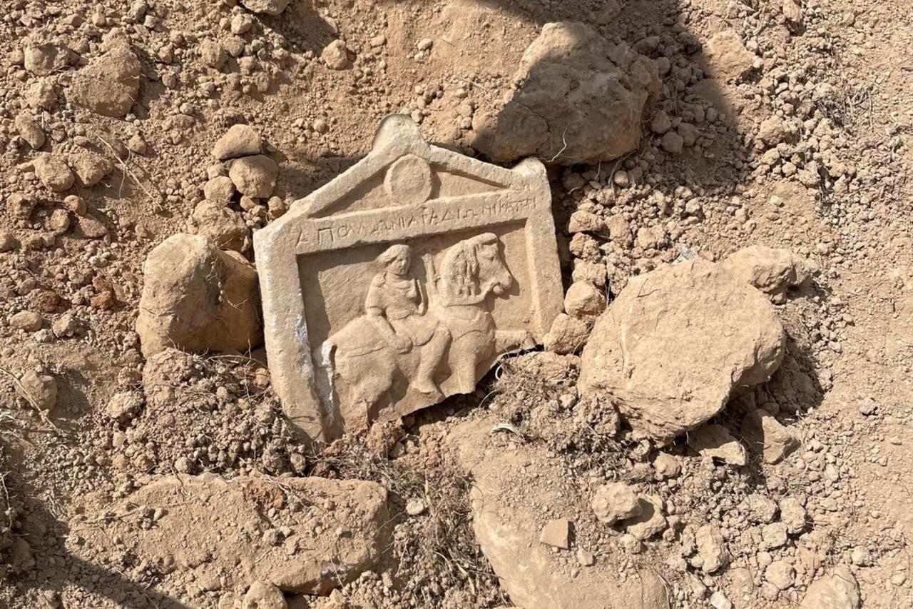 A relief-carved stela depicting a mounted soldier, inscribed with the phrase ‘Apollo’s son, soldier,’ uncovered during landscaping works in Denizli’s Cal district, Türkiye, Aug. 28, 2025. (IHA Photo)
