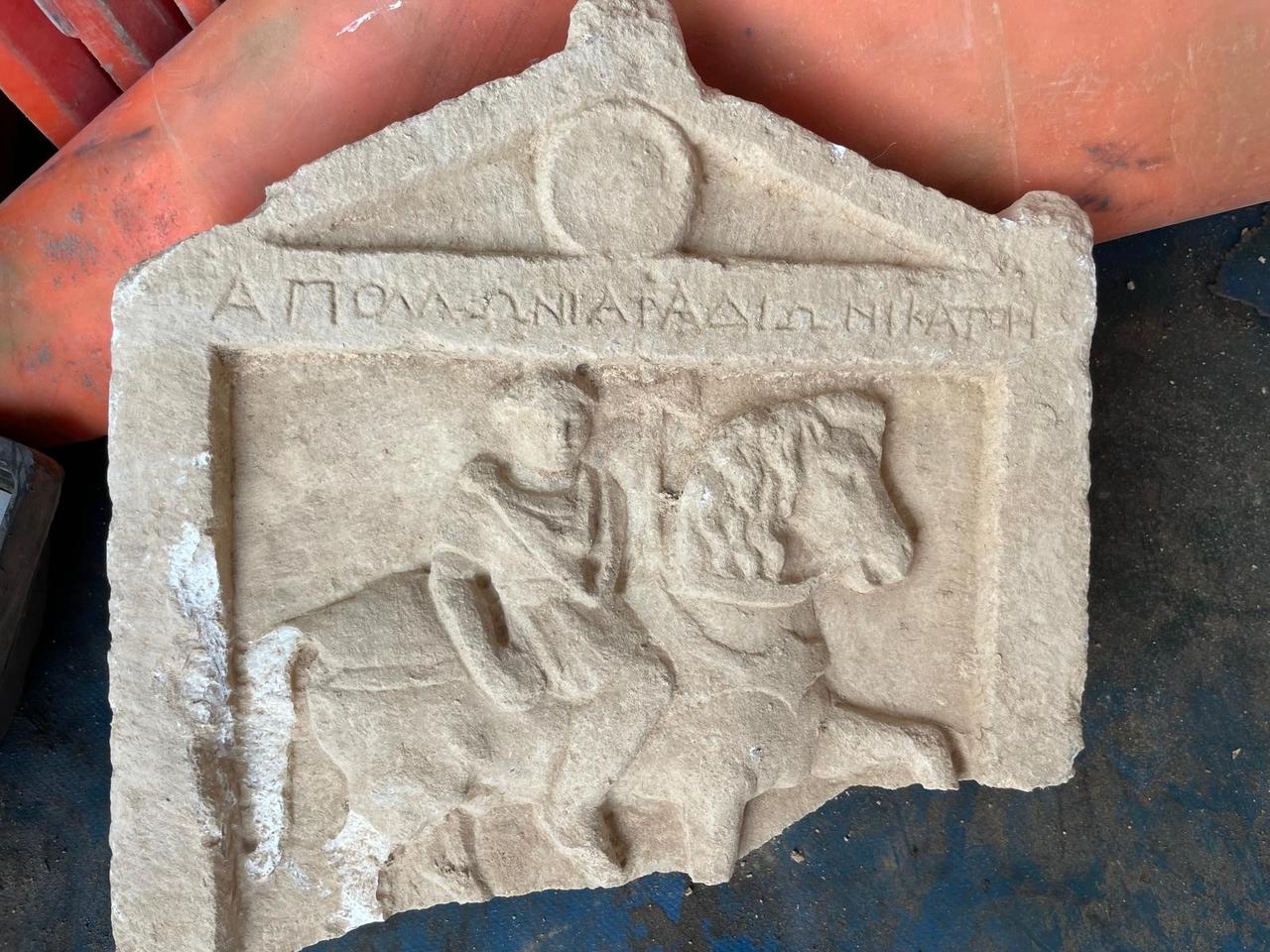 A relief-carved stela depicting a mounted soldier, inscribed with the phrase ‘Apollo’s son, soldier,’ uncovered during landscaping works in Denizli’s Cal district, Türkiye, Aug. 28, 2025. (IHA Photo)