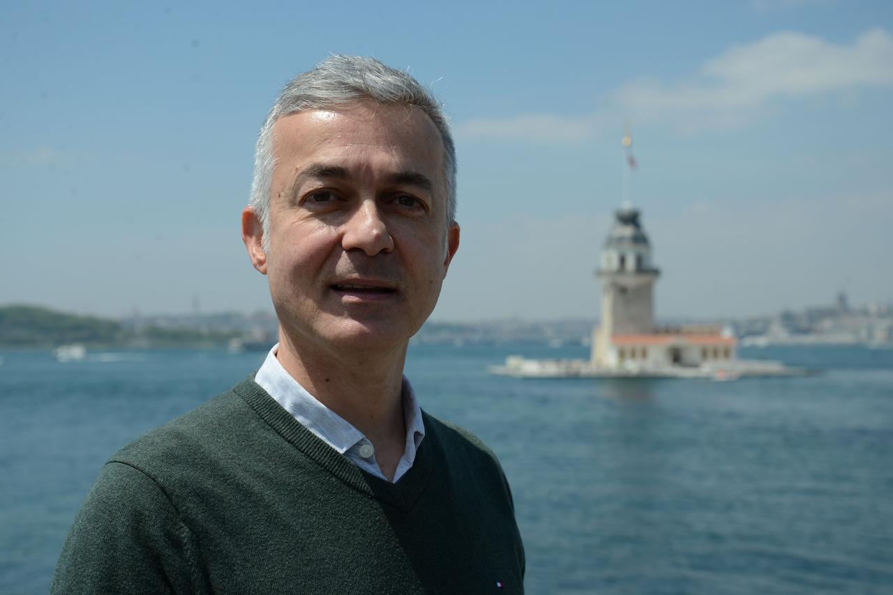Art historian and guide Associate Professor Sedat Bornovali is pictured in Istanbul, with the Maiden’s Tower in the background. (Photo via Türkiye daily)