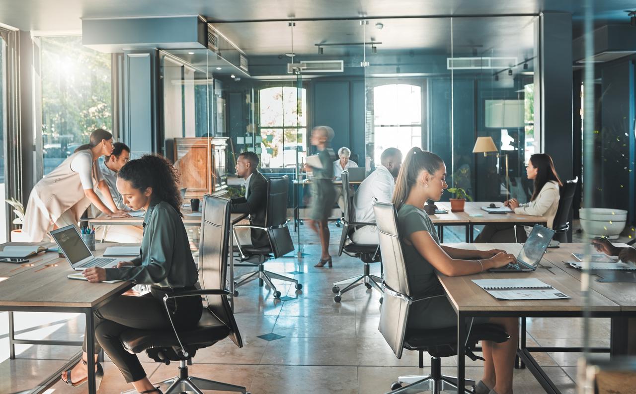 Business professionals working together in a busy office, handling tasks. (Adobe Stock Photo)