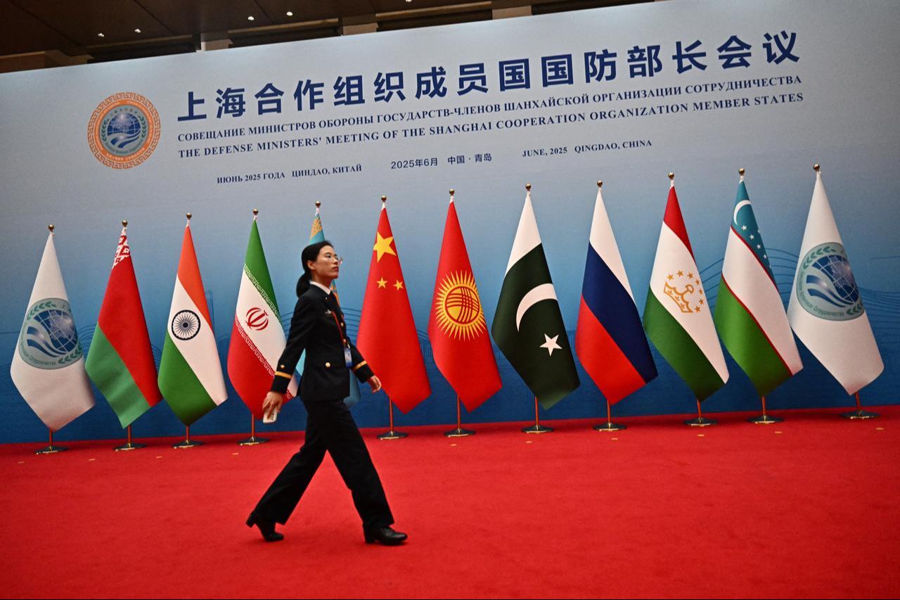 Military personnel walk past flags ahead of the Defense Ministers' Meeting of the Shanghai Cooperation Organization (SCO) Member States in Qingdao, China, on June 26, 2025. (AFP Photo)