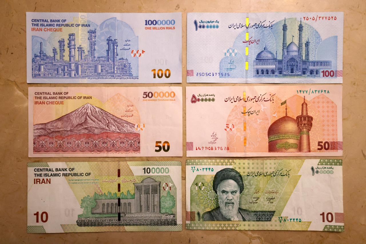 This picture shows old Iranian bank notes of one million, 500,000, and 100,000 rials (L) and the new bankotes with four zeros removed (R) on August 3, 2025. (AFP Photo)