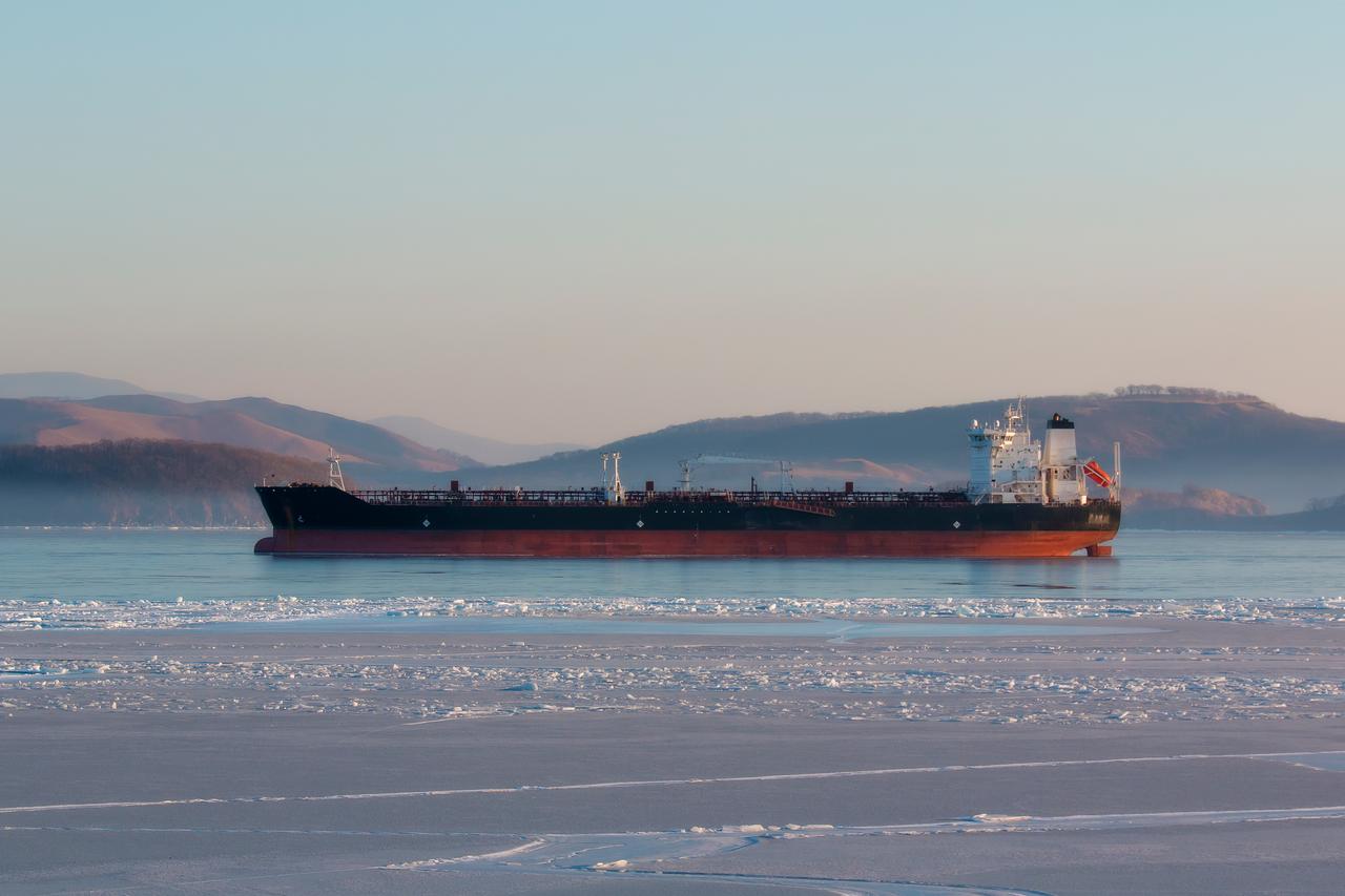 An oil tanker waits offshore amid icy waters near a Russian port. (Adobe Stock Photo)