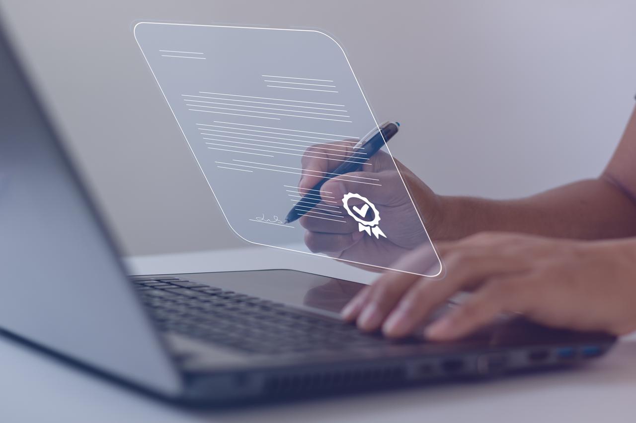 Businessman working on a laptop computer and using a pen to sign electronic documents on digital documents on a virtual screen, accessed on Aug. 5, 2025. (Adobe Stock Photo)