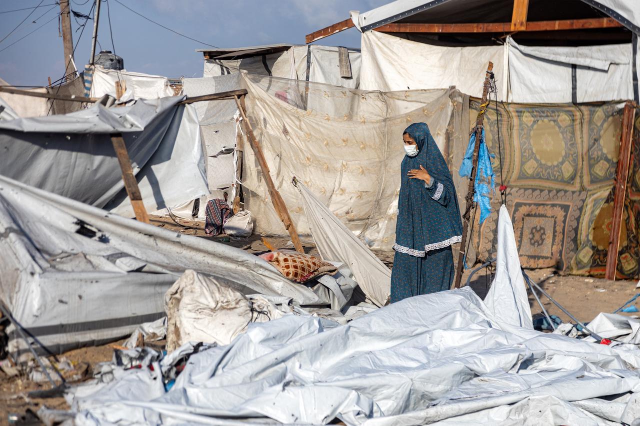 A woman inspects a scene in the aftermath of overnight Israeli bombardment on a camp sheltering displaced people in the Mawasi area of Khan Yunis, southern Gaza Strip on August 5, 2025. (AFP Photo)
