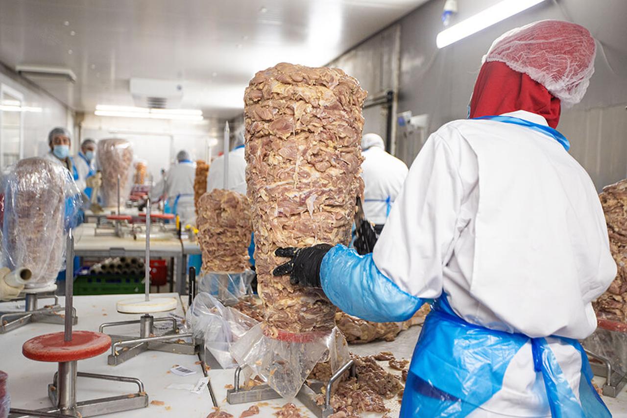 Workers at Birtat's production facility assemble vertical meat skewers for doner kebabs in Germany. (Photo via birtat.com)
