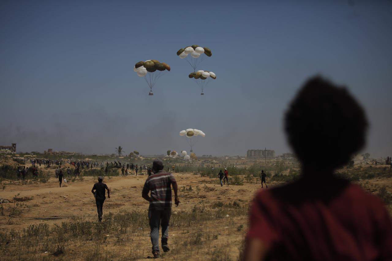 Palestinians wait for hours in hopes of reaching the aid dropped by military aircrafts near Nuseirat, Gaza on August 6, 2025. (AA Photo)