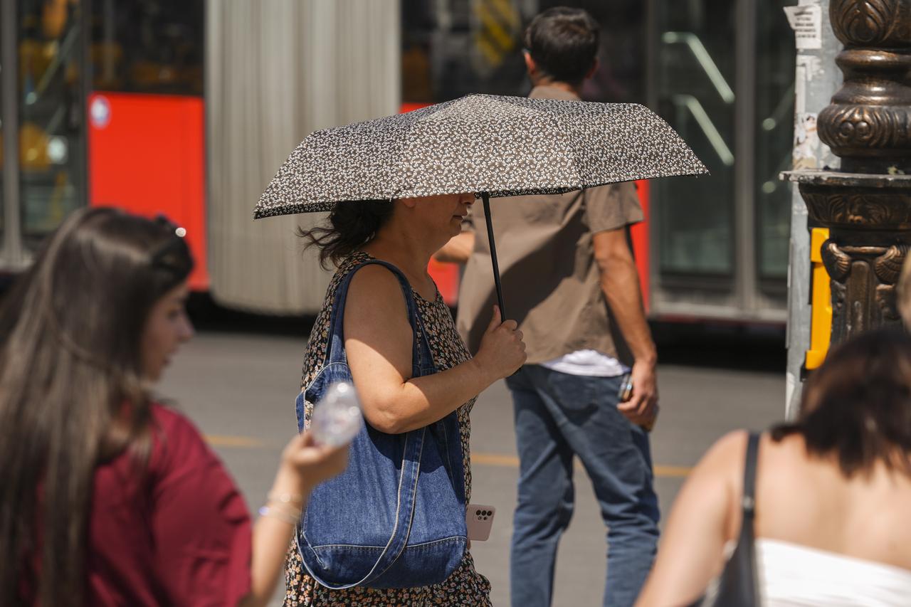 Citizens in busy areas like Ulus, Kalaba, and Kizilay are seen using hats and umbrellas to shield themselves from the sun as midday heat grips Ankara, Türkiye, July 29, 2025. (AA Photo)