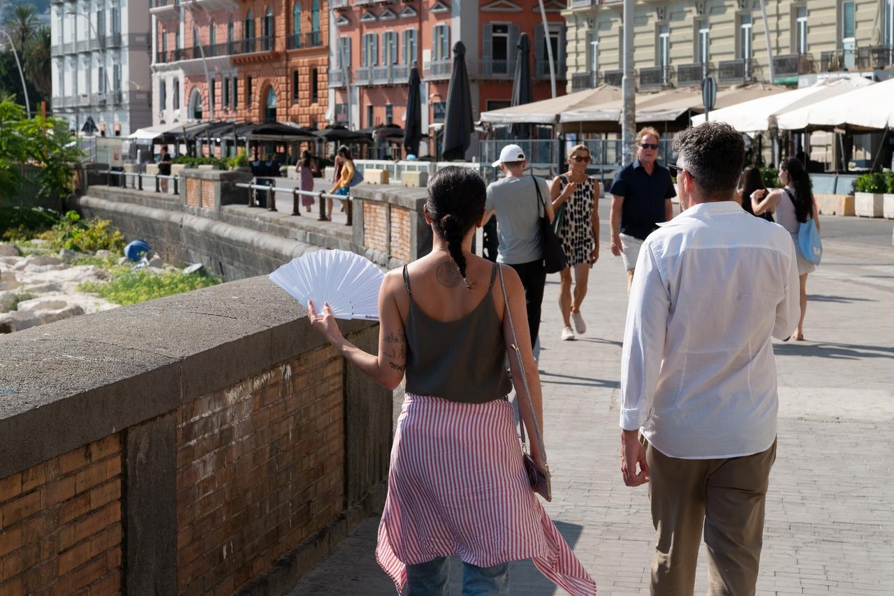 A woman uses a fan during the African heatwave in Naples, Italy, August 6, 2025. (AA Photo)