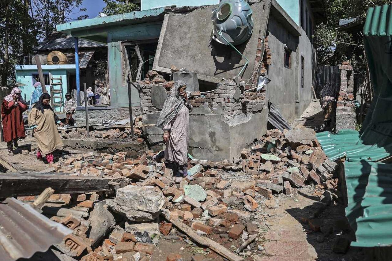 People walk through the debris of a demolished house related to the Pahalgam tourist attack in Monghama village of Tral south of Srinagar on April 25, 2025. (AFP Photo)