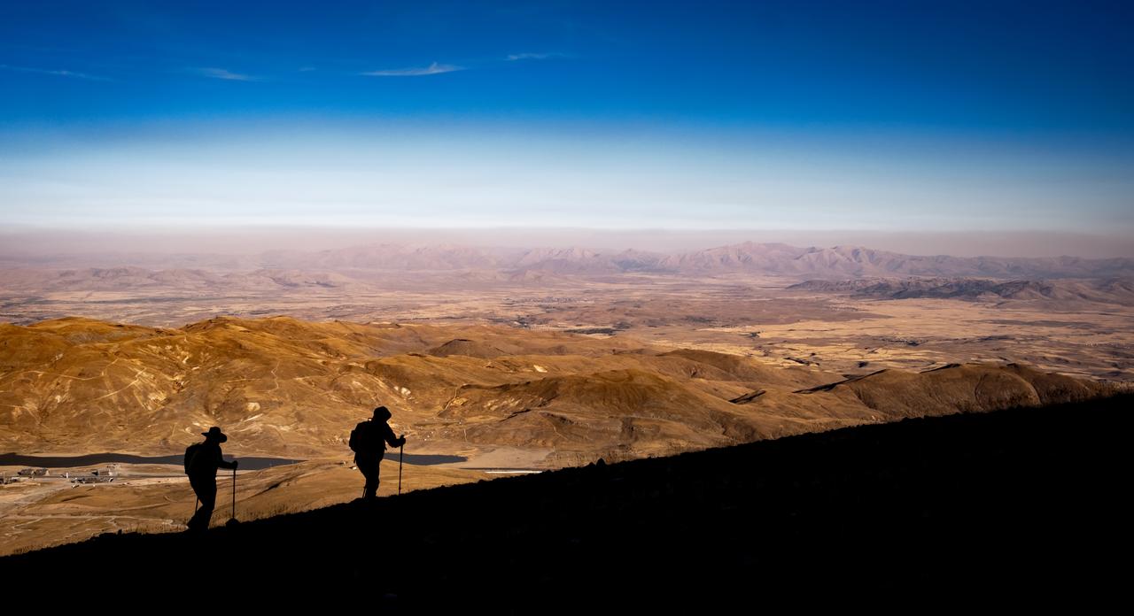 Two hikers enjoy the views while hiking near volcano during sunrise, Erciyes, Türkiye, accessed August 9, 2025. (Adobe Stock Photo)