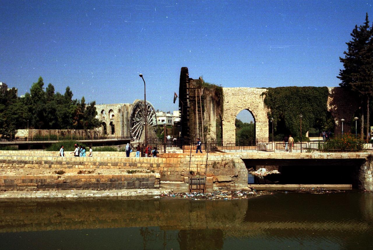 Mamuriyya Noria'nın arka planda göründüğü El-Jisriyya Noria. (Suriye modern tarihinin izniyle fotoğraf)
