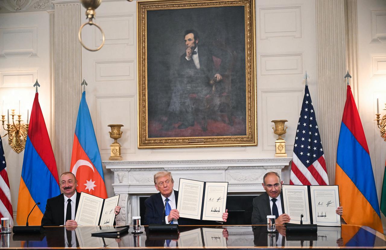 U.S. President Donald Trump (C), Azerbaijani President Ilham Aliyev (L) and Armenian Prime Minister Nikol Pashinyan display the agreement they signed in the State Dining Room of the White House in Washington, U.S. on August 8, 2025. (AFP Photo)