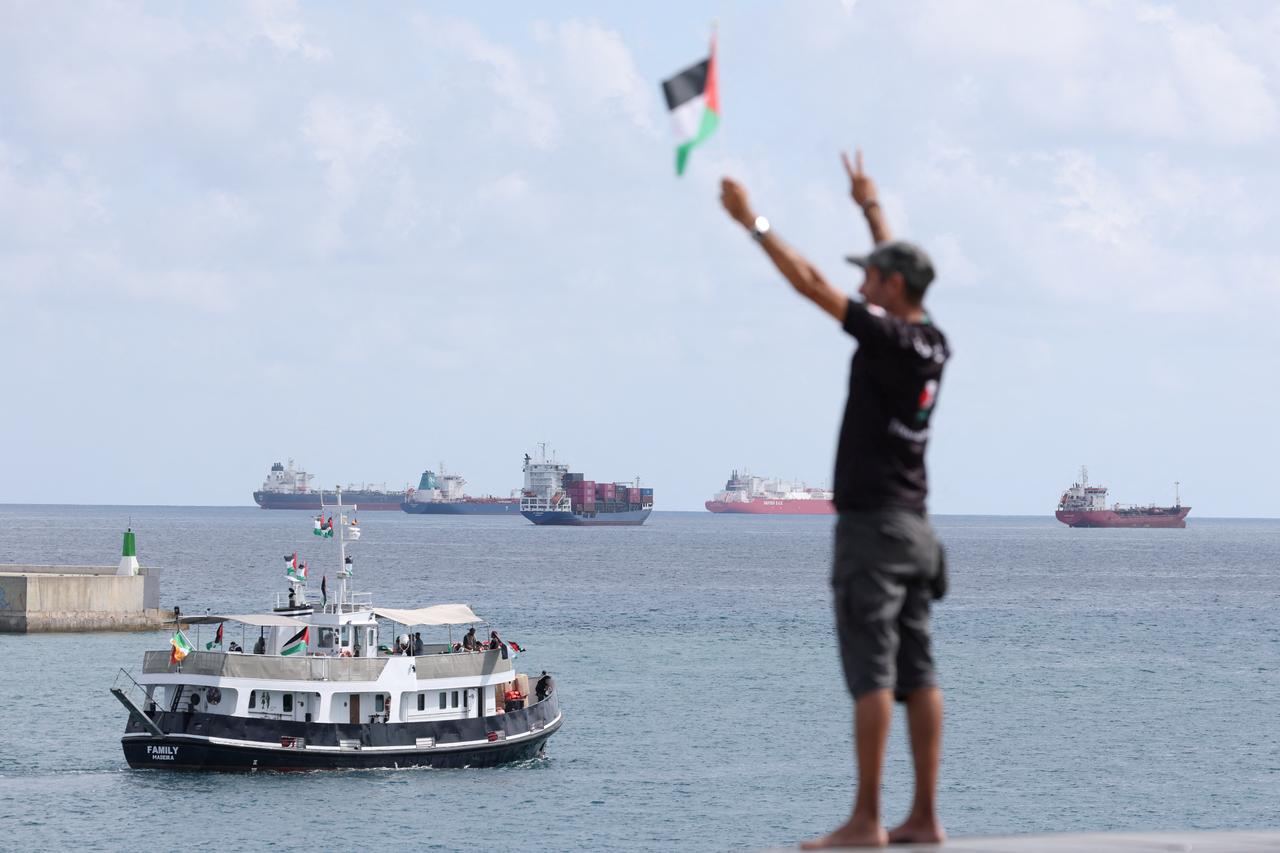 An activist waves the Palestinian flag as a boat carrying activists, part of a civilian flotilla aiming at breaking the Israeli blockade of the Gaza Strip, to break the illegal siege of Gaza, on August 31, 2025 . (AFP photo)