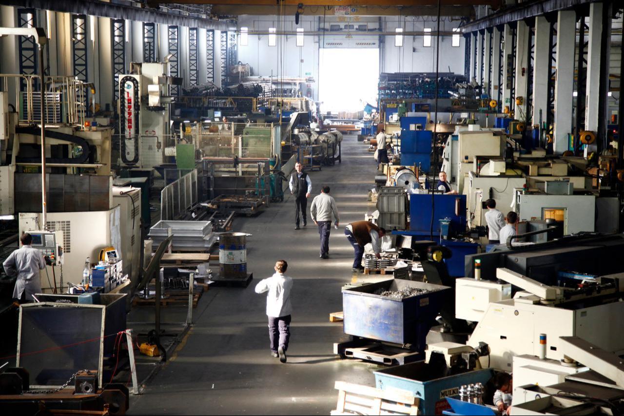 Workers operate machinery on the factory floor of a metal manufacturing plant in Türkiye. (Adobe Stock Photo)