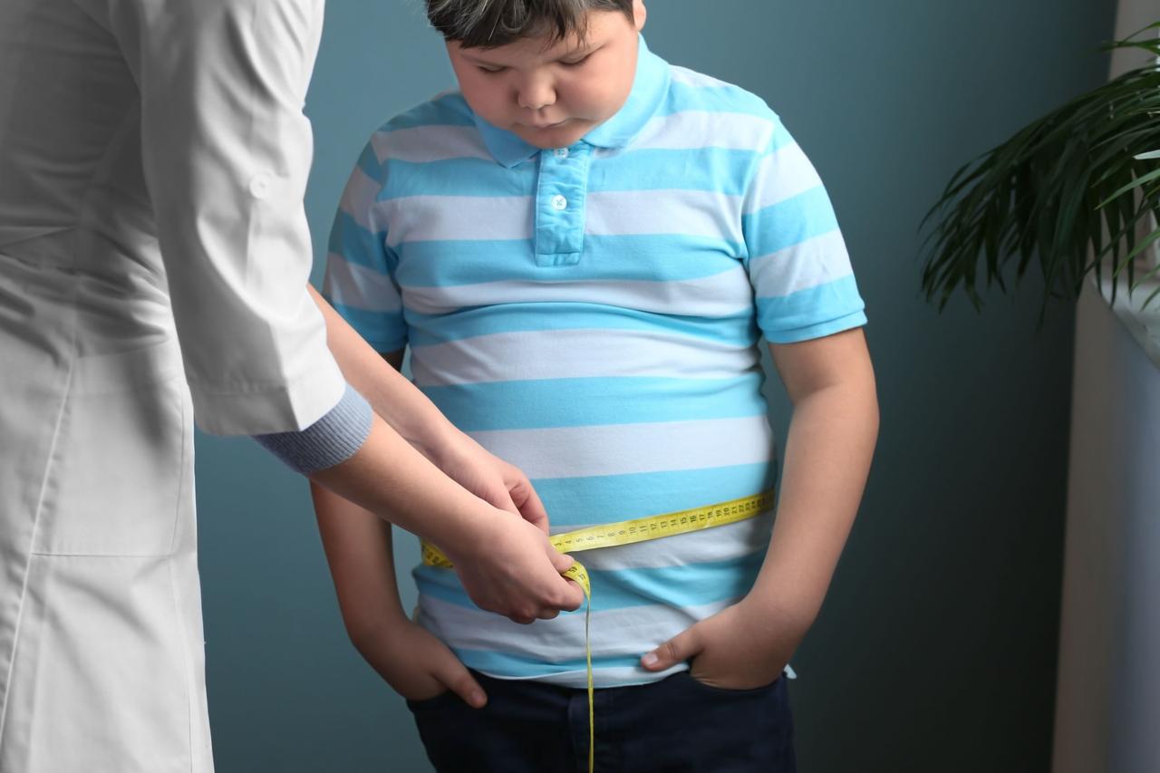 Doctor checking a boys weight in the clinic. (Adobe Stock Photo)