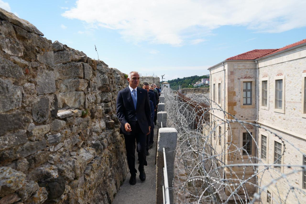 Minister Mehmet Nuri Ersoy walks along the outer walls of the Sinop Historical Prison during the reopening tour of the restored site, Sept. 10, 2025. (Photo via Culture and Tourism Ministry)