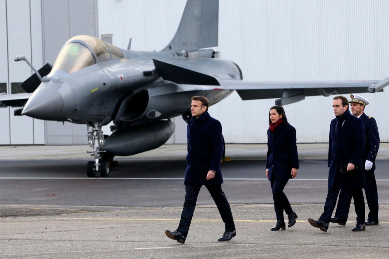 French President Emmanuel Macron, followed by French Armies Minister Sebastien Lecornu (2nd R), walks past a Dassault Rafale fighter aircraft on Jan. 20, 2023. (AFP Photo)