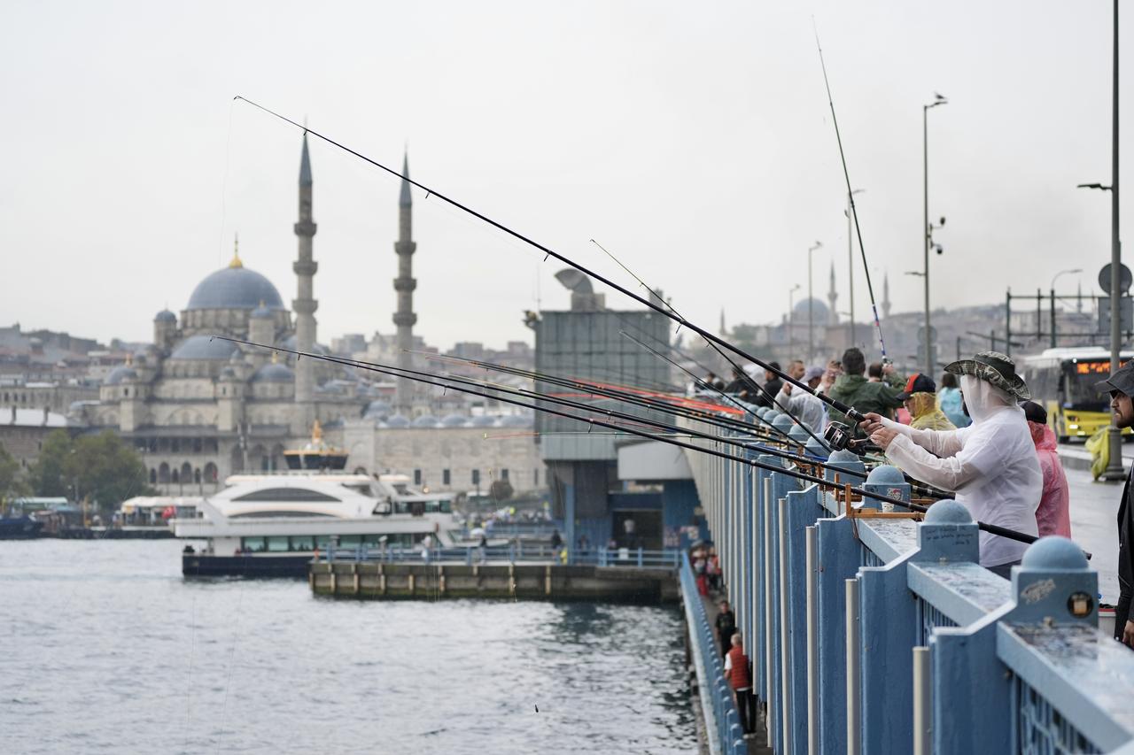 Fishermen cast their lines from Galata Bridge under cloudy skies as light rain falls in Istanbul, Türkiye, September 6, 2025. (AA Photo)