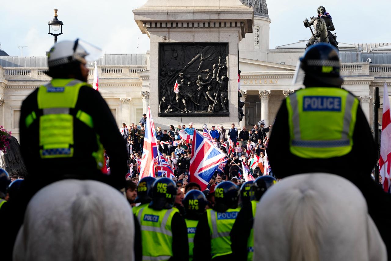 Mounted police officers look on as supporters of British far-right activist Tommy Robinson whose real name is Stephen Yaxley-Lennon, wave flags during a 'Free speech' march, at Trafalgar Square, in London on Sep. 13, 2025. (AFP Photo)