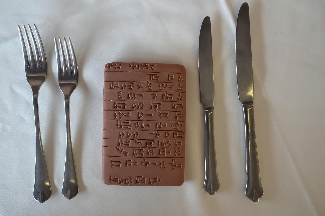 A clay tablet sits on the table as chef Necati Yılmaz prepares an 11-course menu inspired by archaeological research in Istanbul, Türkiye, July 29, 2025. (AA Photo)
