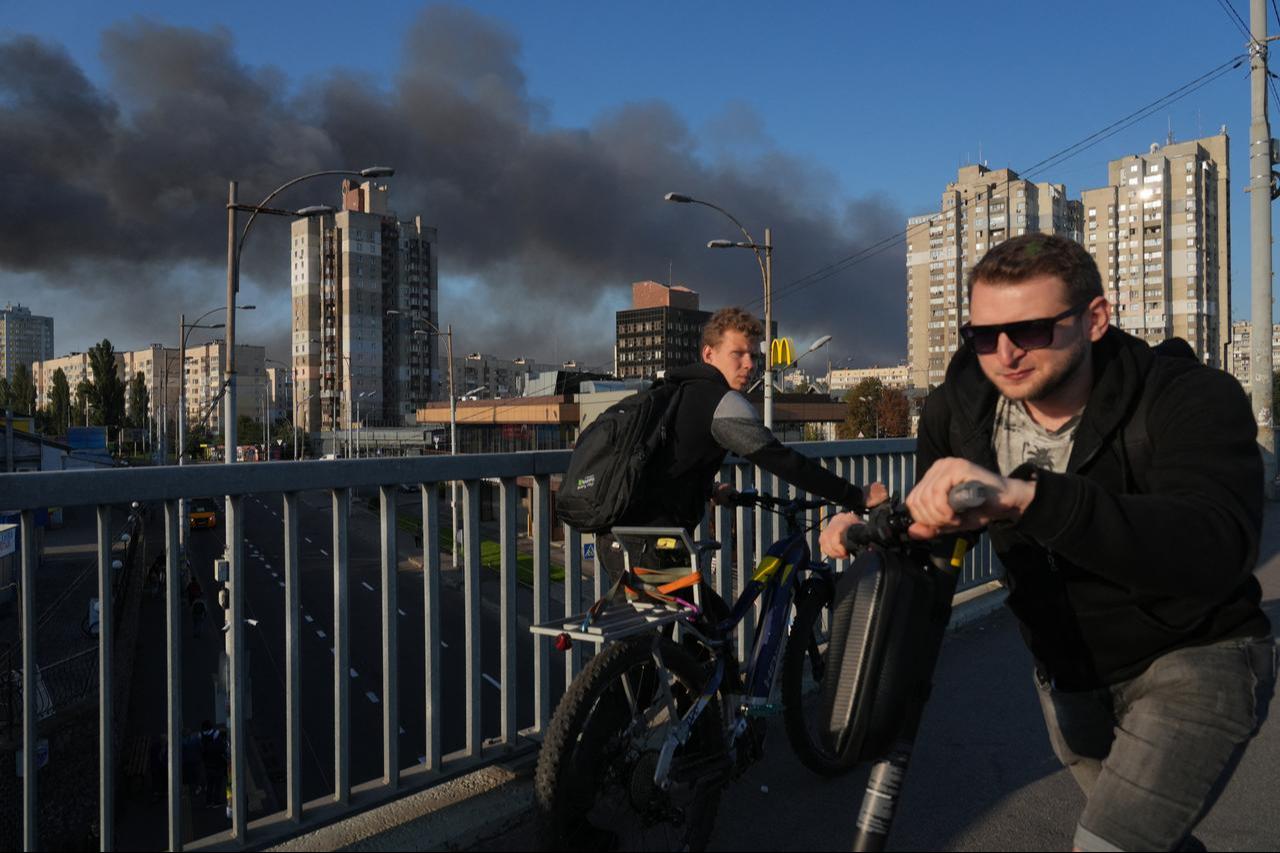 Local residents walk across a bridge as smoke rises following a Russian drone and missile strike in Kyiv, Ukraine, Sept. 7, 2025. (AFP Photo)
