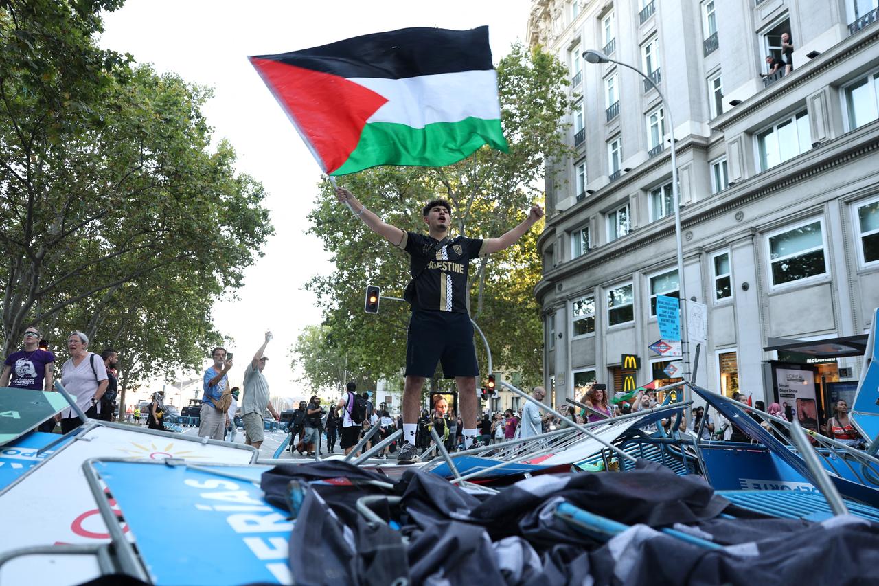 A pro-Palestinians protestor waves a Palestinian flag after the protestors invaded the street during the 21st and last stage of the Vuelta a Espana 2025, near Atocha station in Madrid on Sep. 14, 2025. (AFP Photo)