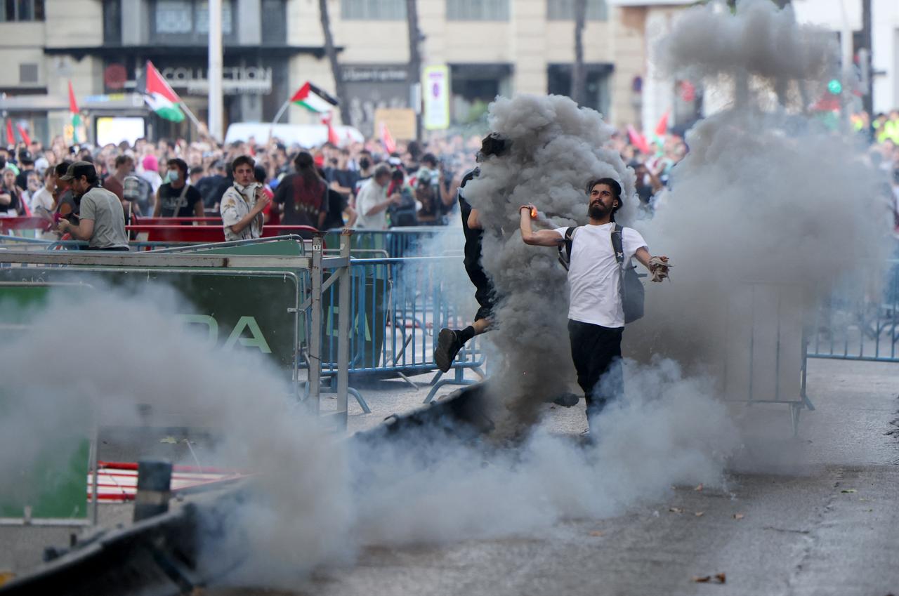 A man throws back to police a tear gas canister after Pro-Palestinians protestors invaded the street during the 21st and last stage of the Vuelta a Espana 2025, in Madrid on Sep. 14, 2025. (AFP Photo)