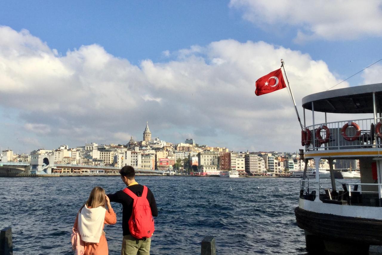 Young couple by the waterfront looking over the Golden Horn in Istanbul, Türkiye. (Adobe Stock Photo)