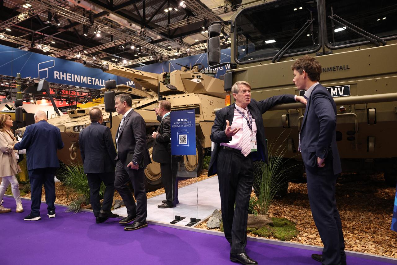 Delegates talk at the Rheinmetall stand next to a HX 10x10 heavy repair and recovery vehicle at the Defense and Security Equipment International (DSEI) fair in London, Sept. 9, 2025. (AFP Photo)