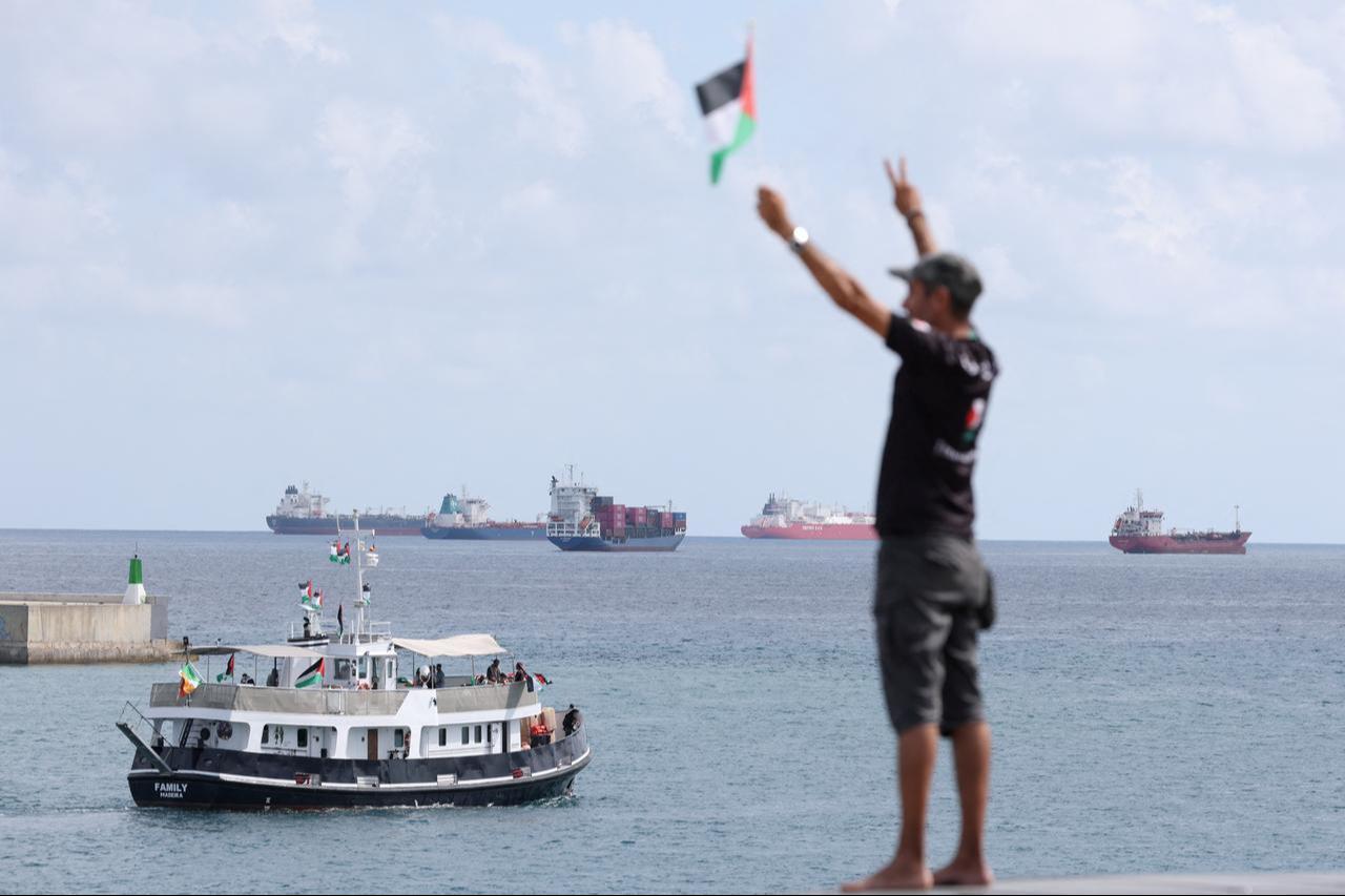 An activist waves the Palestinian flag as a boat carrying activists, part of a civilian flotilla aiming at breaking the Israeli blockade of the Gaza Strip, to break the illegal siege of Gaza, on August 31, 2025 . (AFP photo)