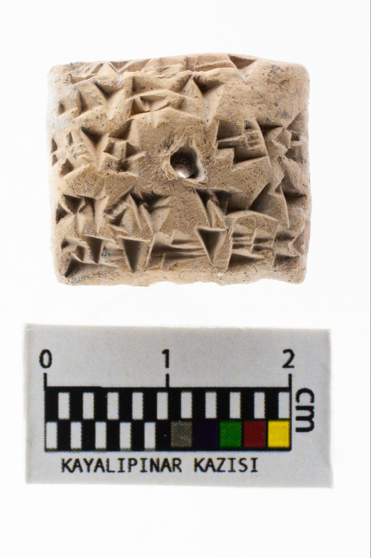 A miniature Hittite cuneiform tablet unearthed during the Kayalipinar excavations in Sivas, Türkiye, Sept. 16, 2025. (AA Photo)