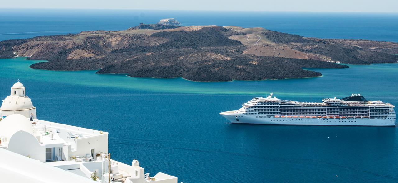 A cruise ship sails near the volcanic islets of Santorini during the summer tourist season, Santorini, Greece, accessed September 18, 2025. (Adobe Stock Photo)