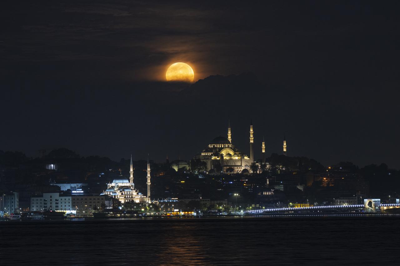 Full moon rises over Suleymaniye Mosque and Yeni Mosque in Istanbul, Türkiye, September 07, 2025. (AA Photo)