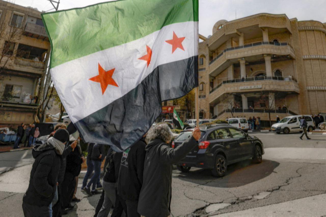 Druze residents of the village of Majdal Shams in the Israeli-annexed Golan Heights wave a Syrian flag as they take part in a rally on February 14, 2025. (AFP Photo)