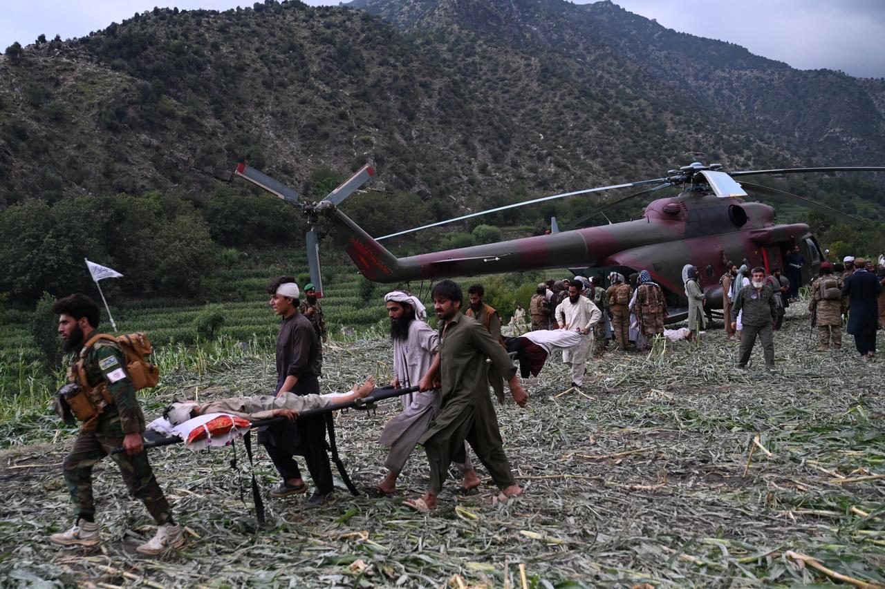 Afghan volunteers and Taliban security personnel work to move injured people near a military helicopter following earthquakes in the Mazar Dara village of Nurgal, a district of the Kunar Province, in Eastern Afghanistan, Sept. 1, 2025. (AFP Photo)