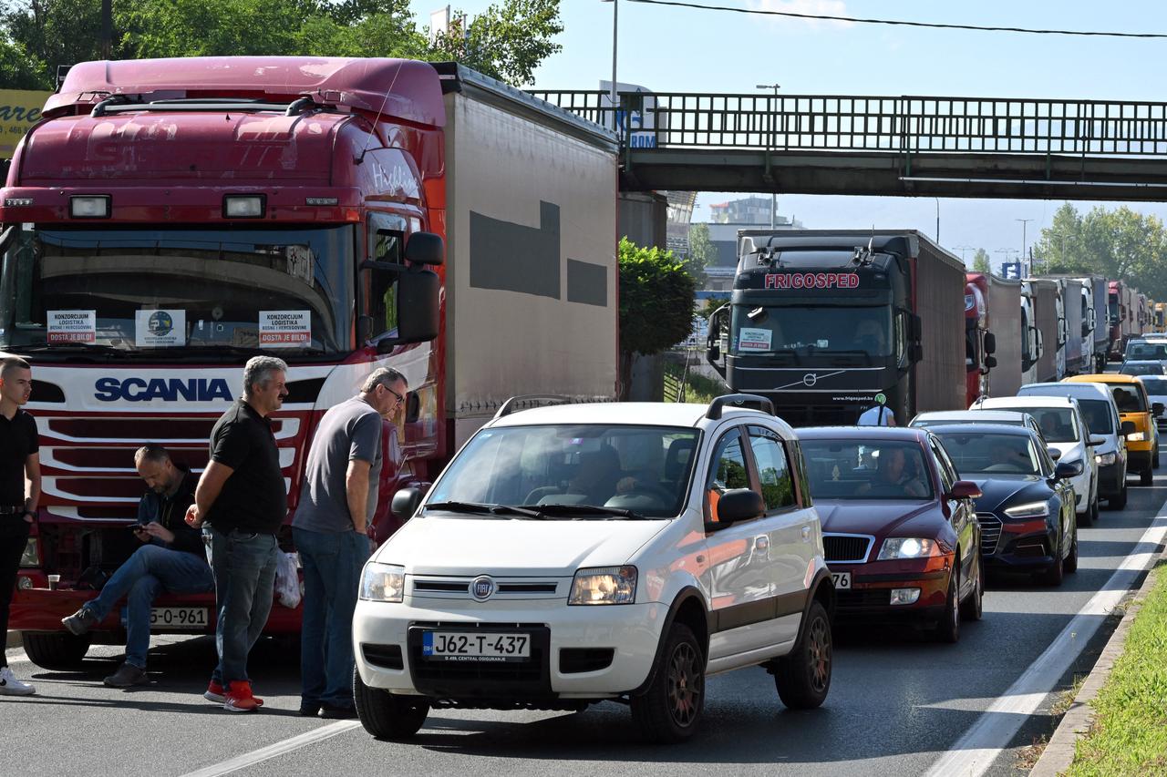 Vehicles drive past trucks partially blocking a highway exit leading towards the Bosnian capital of Sarajevo, Bosnia and Herzegovina on Sept. 1, 2025. (AFP Photo)