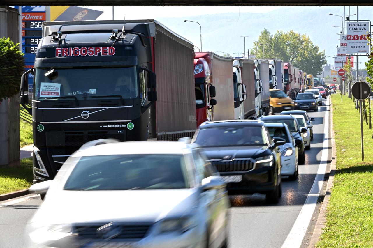 Vehicles drive past trucks partially blocking a highway exit leading towards, Sarajevo, Bosnia and Herzegovina on September 1, 2025. (AFP Photo)