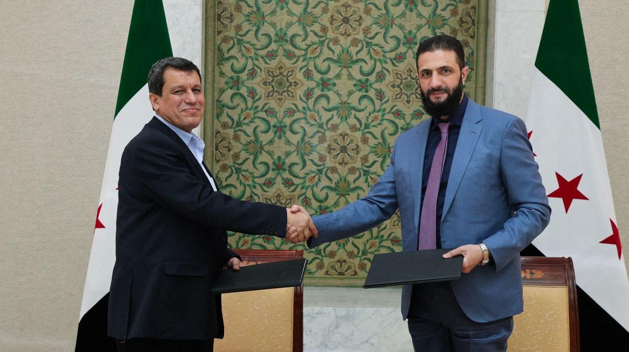 Syria's interim president Ahmed al-Sharaa (R) shaking the hand of YPG/SDF's so-called commander-in-chief Ferhat Abdi Sahin, also known as Mazloum Abdi after the signing of an agreement in the Syrian capital Damascus, March 10, 2025. (SANA Photo / Handout / AFP)