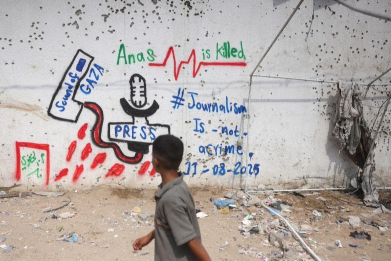 A Palestinian boy looks at graffiti on the wall at the site where a deadly Israeli strike destroyed an Al Jazeera tent and killed six journalists at the Al-Shifa Hospital in Gaza City, Palestine, August 12, 2025. (AFP photo )